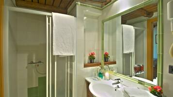 Un baño con ducha, lavabo y espejo.