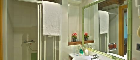 A bathroom with a shower, sink, and mirror.