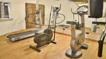 A gym with a treadmill, elliptical, and stationary bike.
