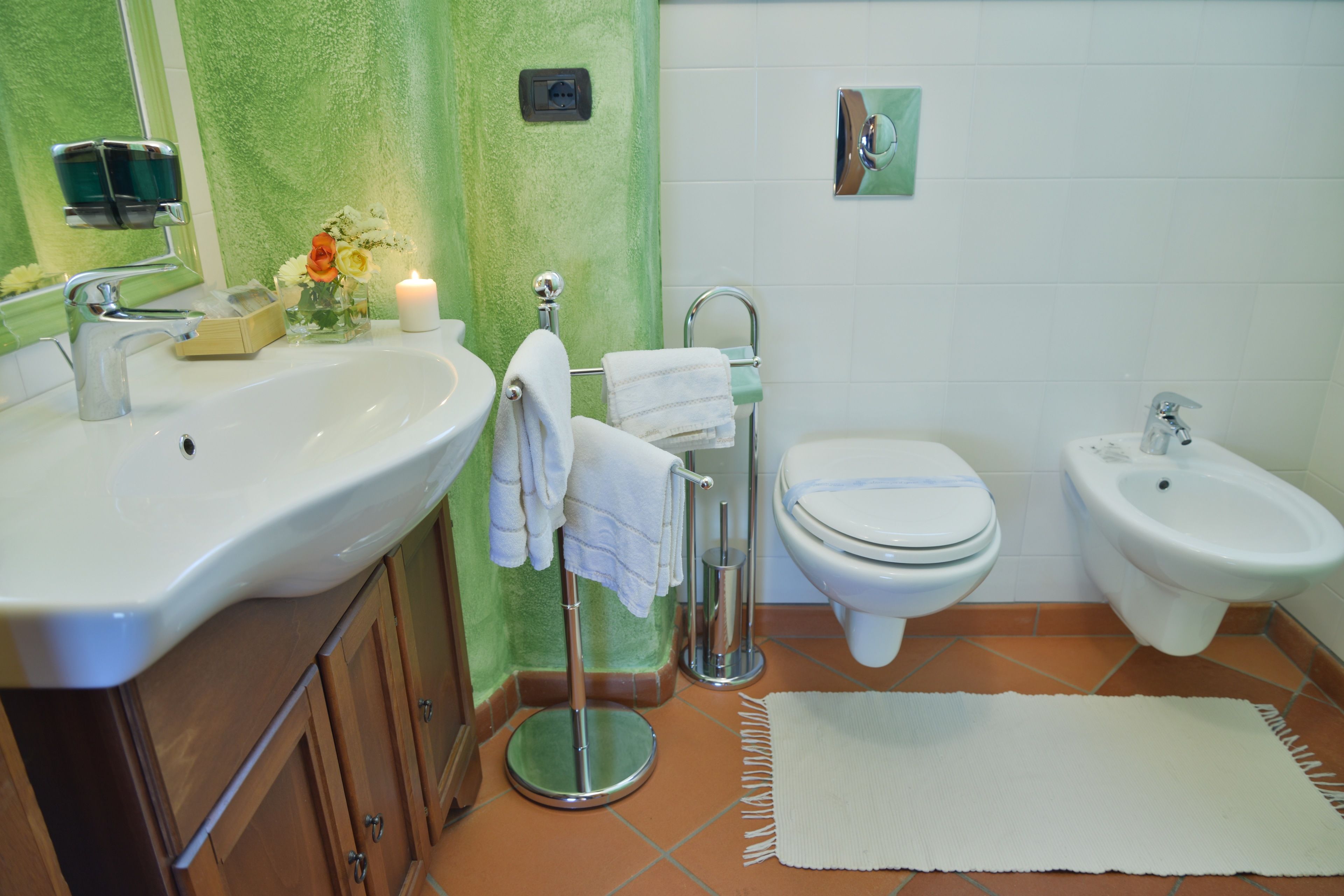 Un bagno con lavandino, wc, bidet e porta asciugamani.
