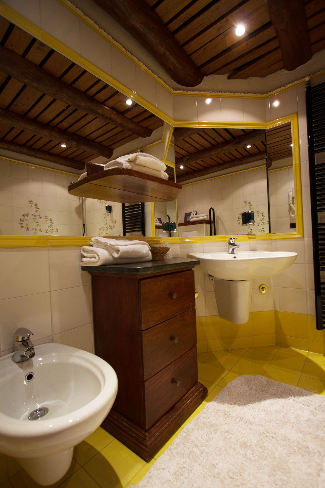 Un baño con tocador de madera, lavabo y bidé.