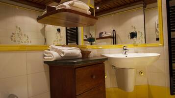 Ein Badezimmer mit einem Holzlagerfläschchen, einem Waschbecken und einem Bidet.