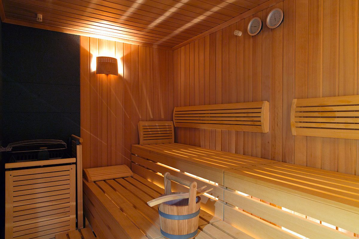 Un sauna avec des bancs en bois et un seau.