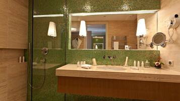 A bathroom with a large mirror, two sinks, a shower, and a towel rack.