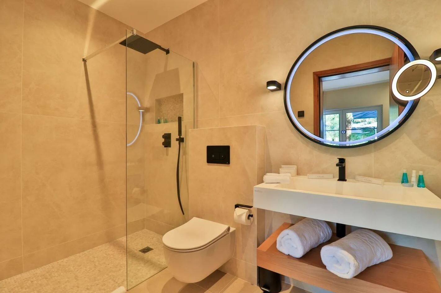 Ein modernes Badezimmer mit einer Duschkabine, Toilette, Waschbecken mit Spiegel und Handtuchhalter.