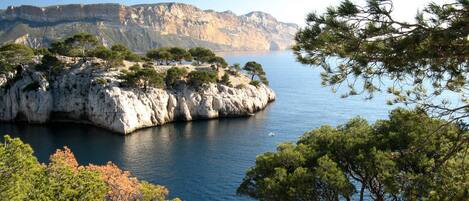A coastal landscape with rocky cliffs and a calm sea.