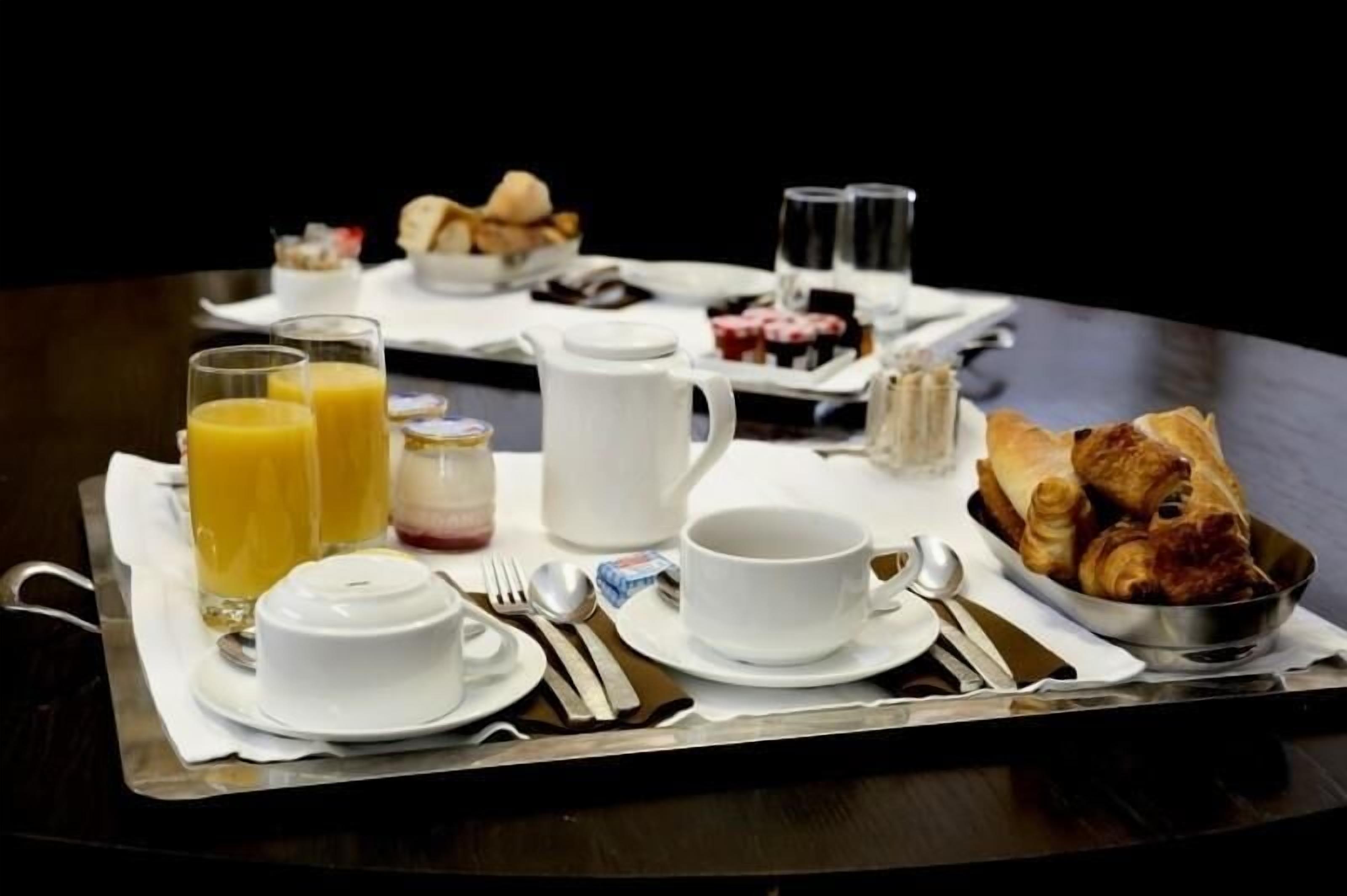 Ein Frühstücksbrett mit Croissants, Saft, Kaffee und Gebäck.