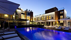 A modern hotel with a swimming pool, outdoor seating, and a well-lit facade. - Hostellerie La Farandole (Sanary-sur-Mer)