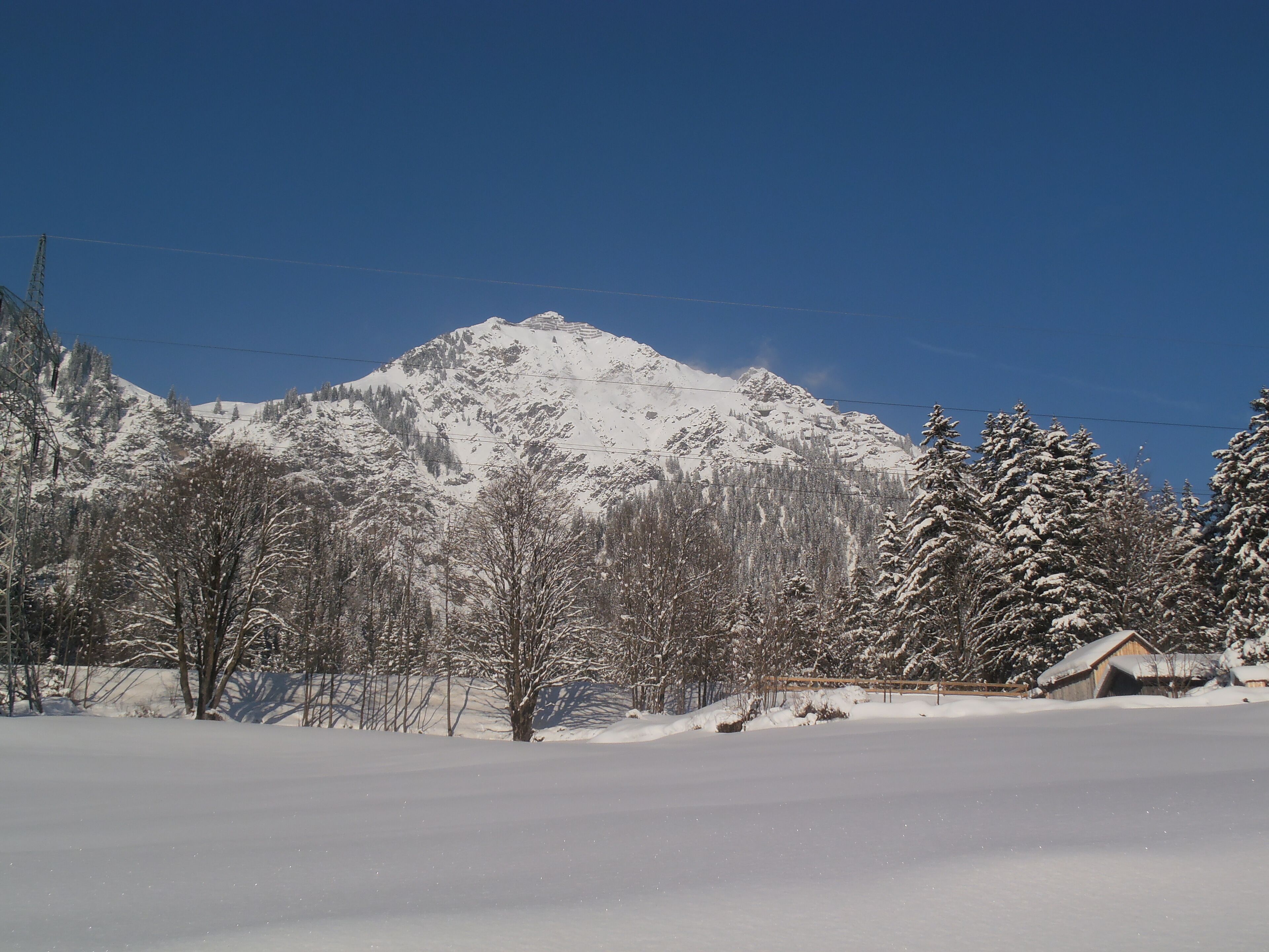 Un paysage de montagne enneigé sous un ciel dégagé.