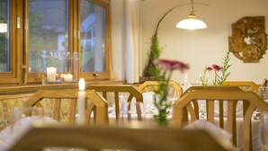 Ein Esstisch mit Stühlen, Kerzen und einer Blumenvase.