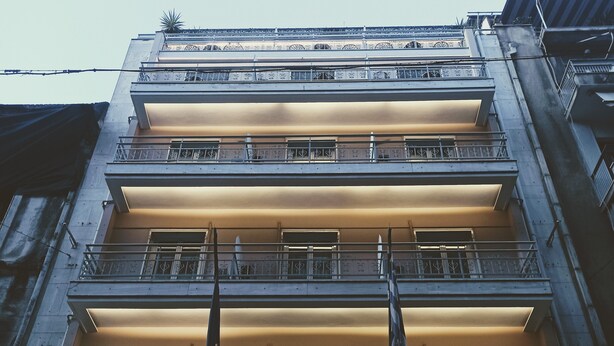 Un hôtel à plusieurs étages, doté de balcons et d’une enseigne indiquant « HÔTEL SOLOMONOU ATHÈNES ».