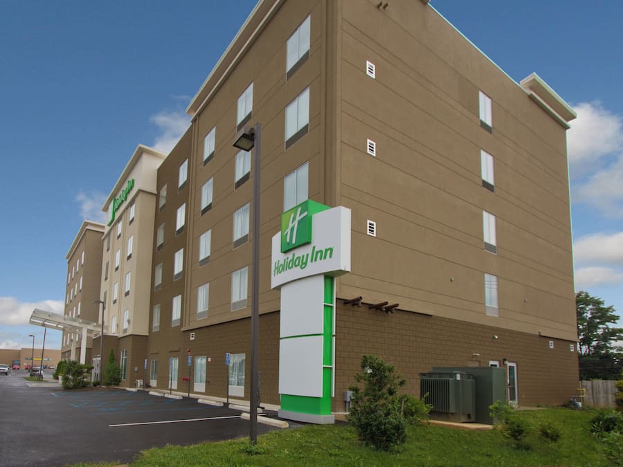 Un hôtel Holiday Inn avec une façade en briques, de nombreuses fenêtres et un parking.