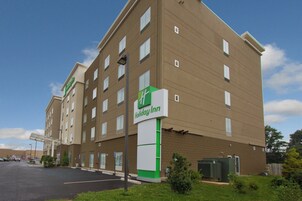 Un hotel Holiday Inn con fachada de ladrillo, varias ventanas y un estacionamiento.