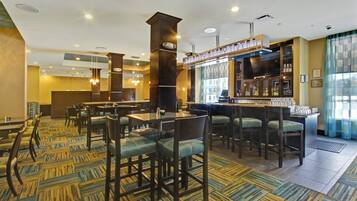 A hotel lobby with a bar area, seating arrangements, and a patterned carpet.