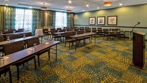 A conference room with tables and chairs, a podium, and framed artwork on the wall. - Holiday Inn Christiansburg Blacksburg by IHG (Christiansburg)