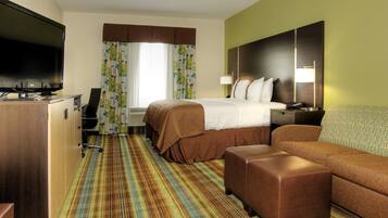 A hotel room with a bed, a TV, a desk, and a couch.