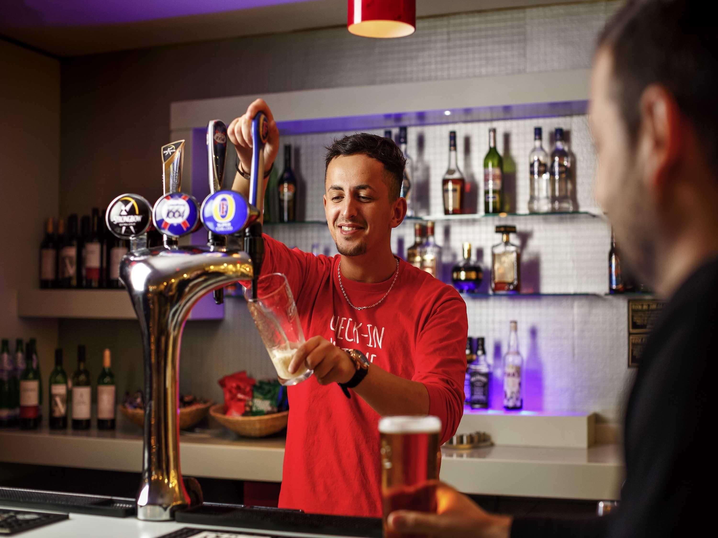 Un barman sert une boisson à partir d’un robinet qui propose plusieurs sortes de bière.