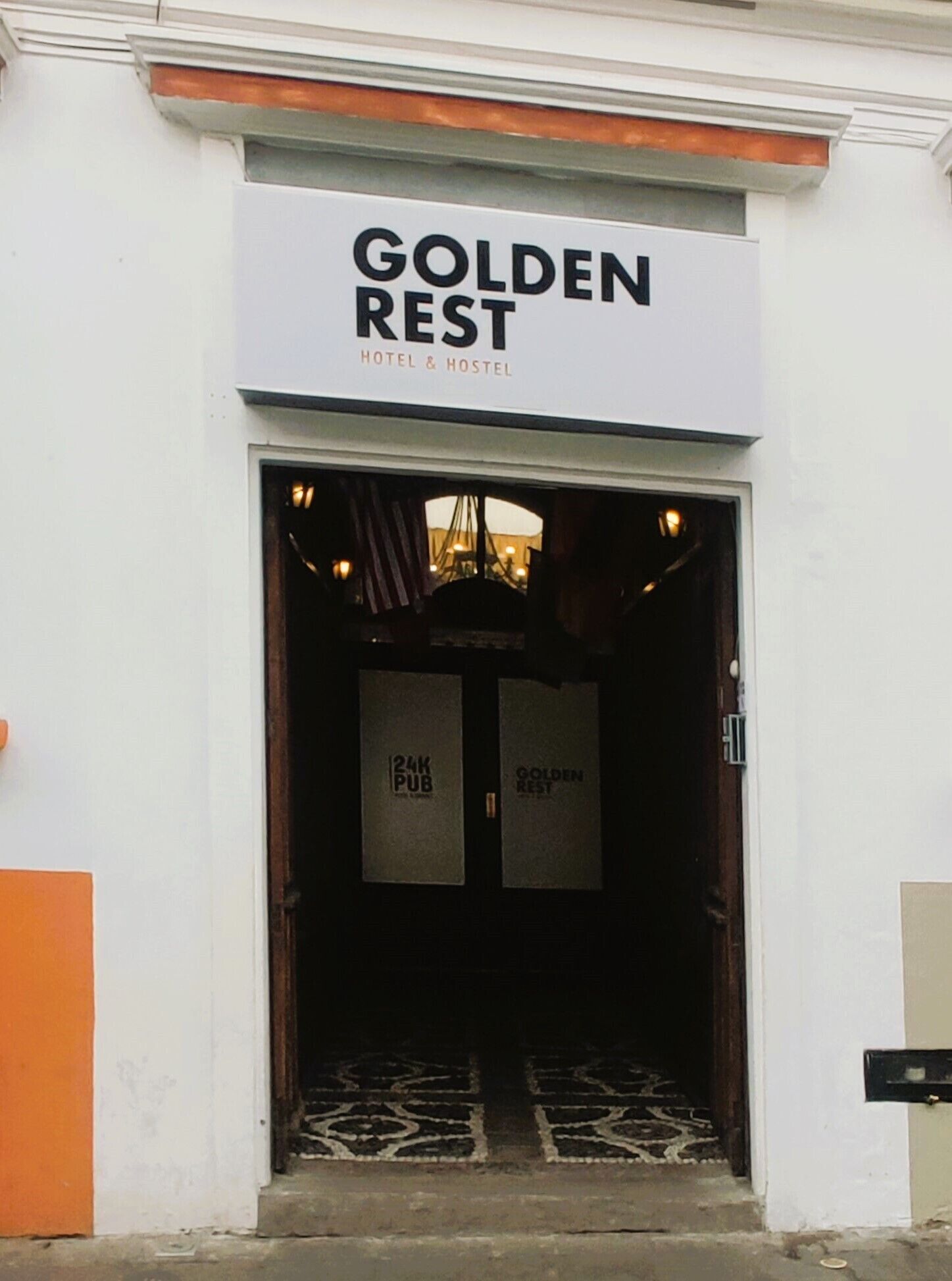 The entrance to Golden Rest Hotel & Hostel with a sign above the door.