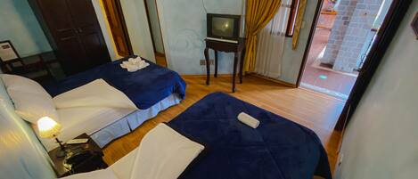 Una habitación de hotel con dos camas, televisión y una pequeña mesa.