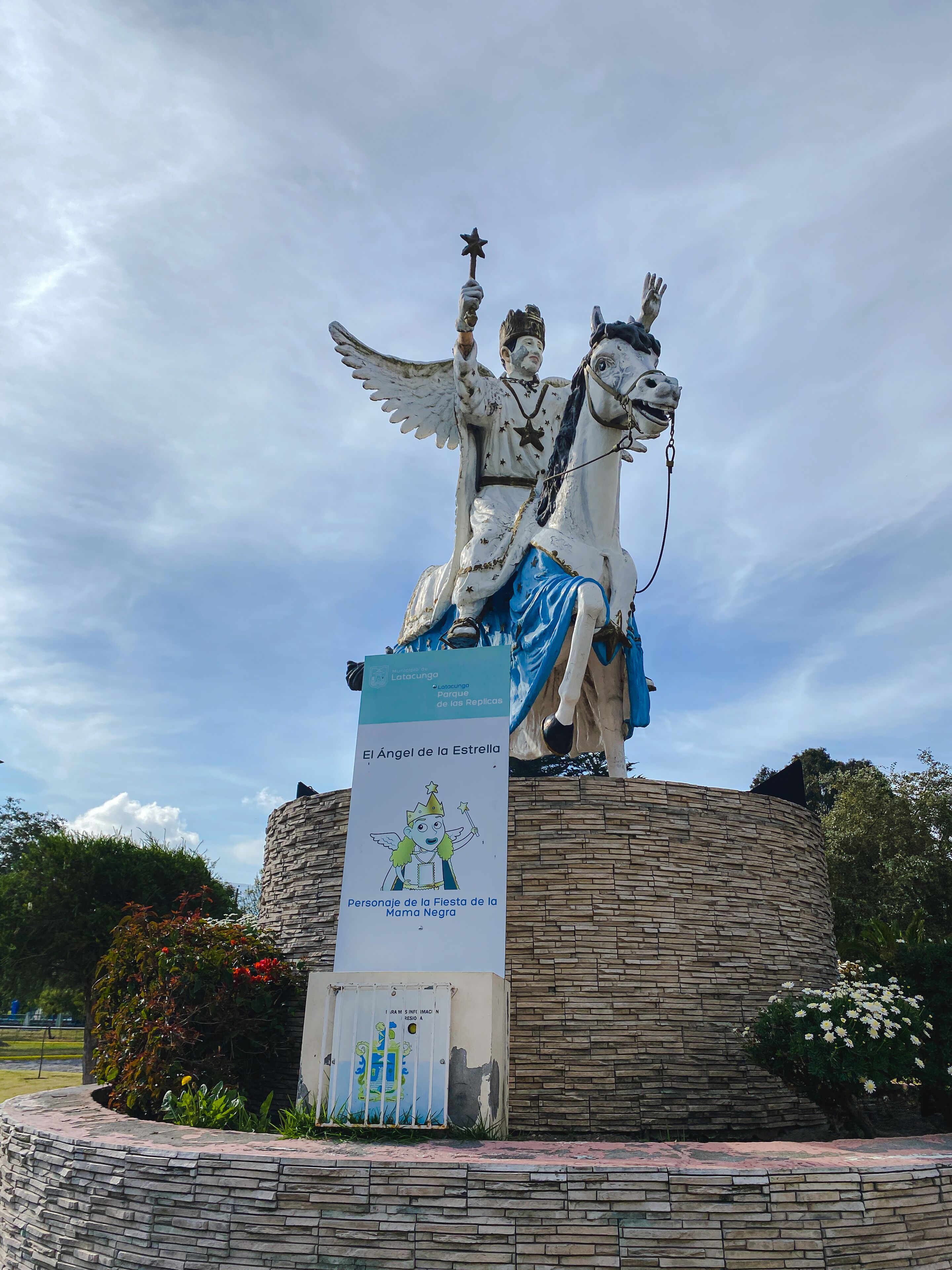 A statue of an angel with a star on its head, mounted on a stone structure.