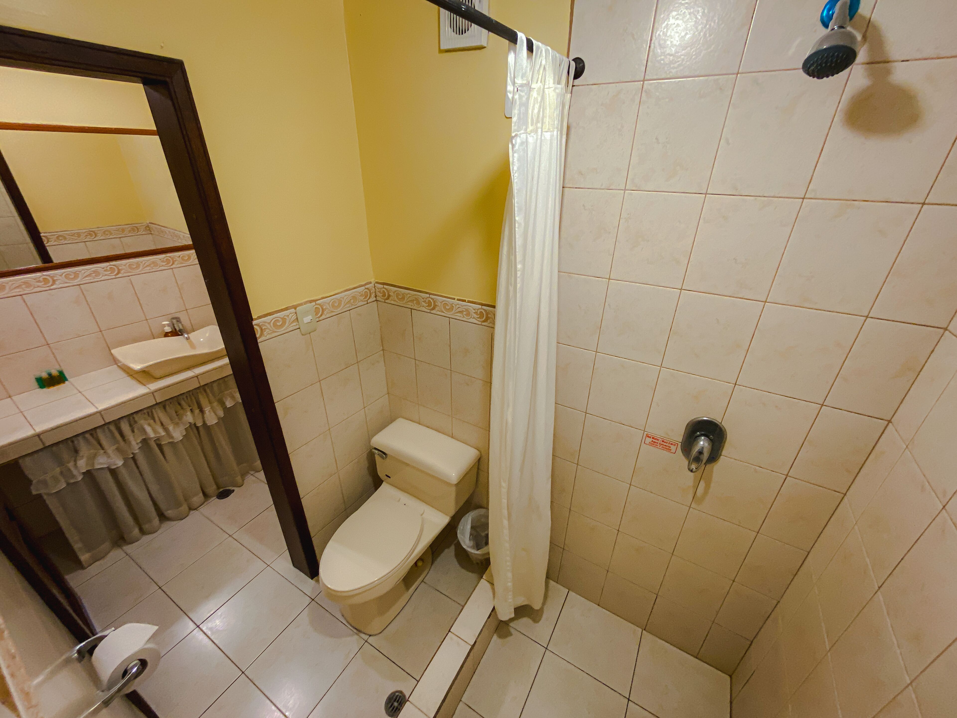 Un baño con inodoro, lavamanos y ducha.