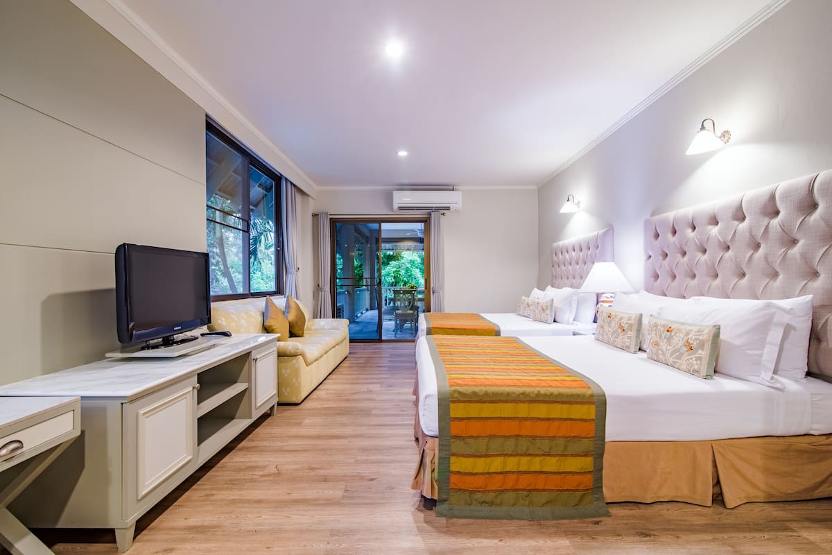 Een hotelkamer met een bed, een televisie, een bureau en uitzicht op de omgeving.