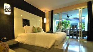 Una habitación de hotel moderna con una cama grande, un televisor de pantalla plana y un balcón con vistas al exterior.