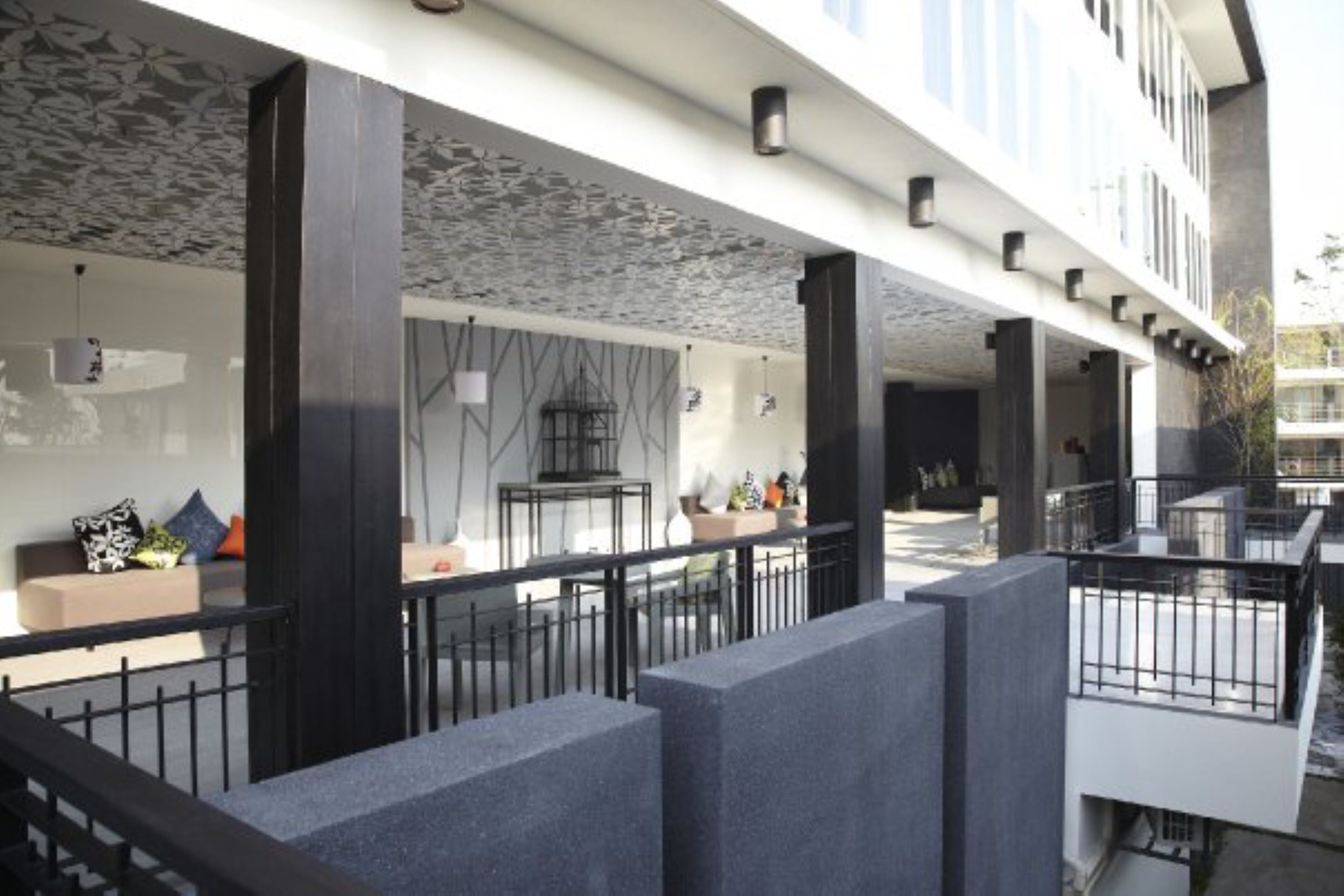 A modern outdoor area with a seating arrangement and a staircase leading to an upper level.