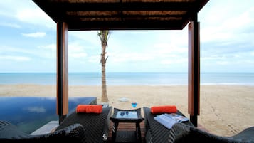 En la playa, sillas reclinables de playa, sombrillas, bar en la playa