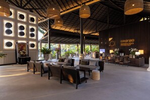 Un'ampia hall con reception, zona salotto e grandi finestre.