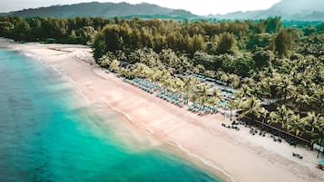 En la playa, sillas reclinables de playa, sombrillas, bar en la playa