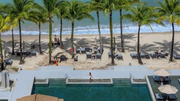 Een buitenzwembad, parasols bij het zwembad en ligstoelen