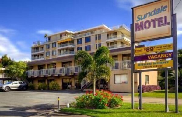 Un motel con un letrero que anuncia 89 dólares por noche y habitaciones disponibles.
