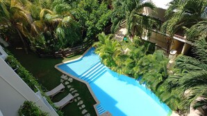 A swimming pool surrounded by lush greenery and a wooden deck. - Posada Sian Kaan Playa del Carmen - Wellness Oriented Hotel (Playa del Carmen)