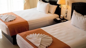 Two single beds with white linens and orange bedspreads, a nightstand with a lamp, and a window with curtains. - Posada Sian Kaan Playa del Carmen - Wellness Oriented Hotel (Playa del Carmen)
