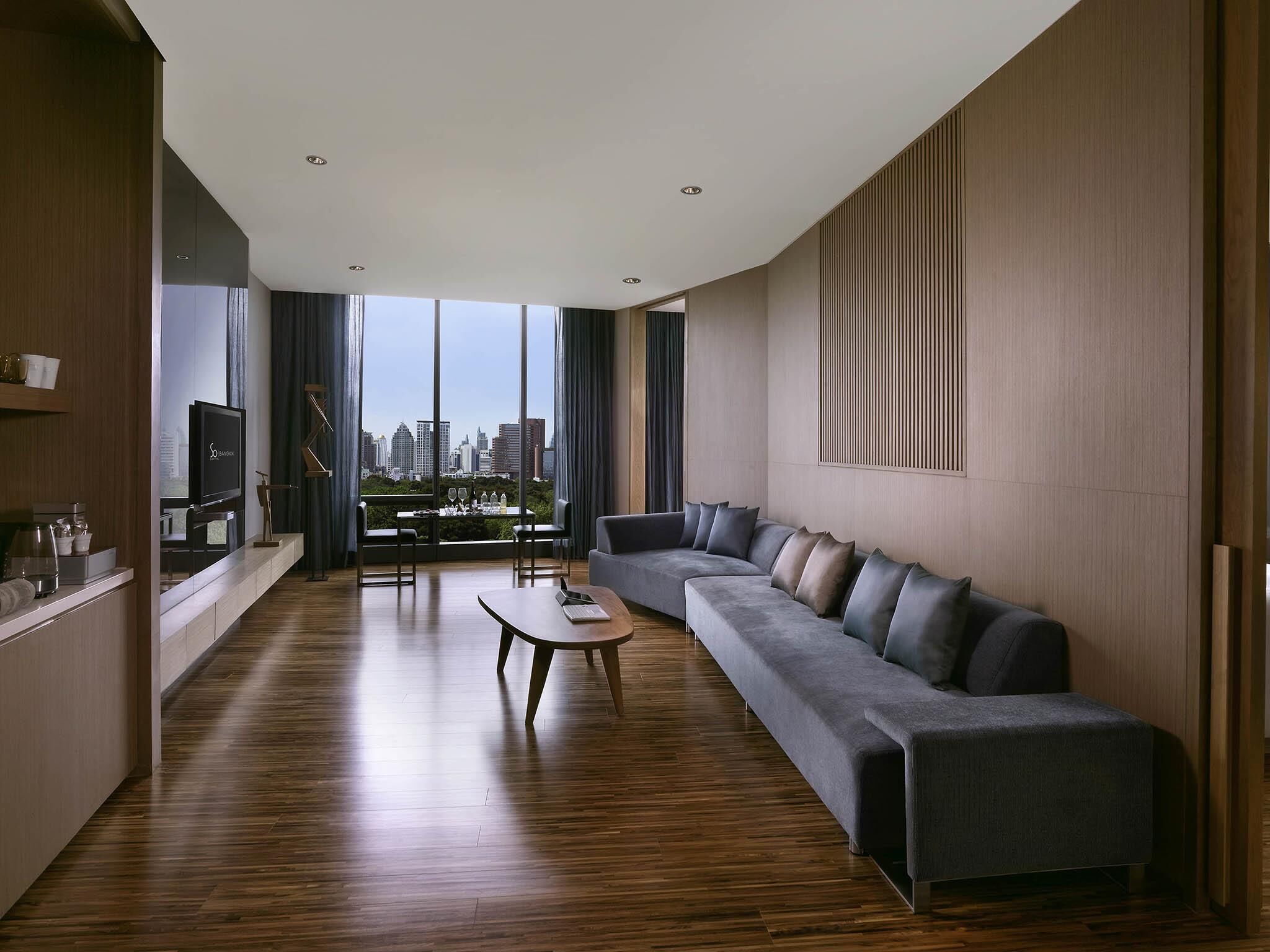 A modern living room with a sofa, a coffee table, and a TV.