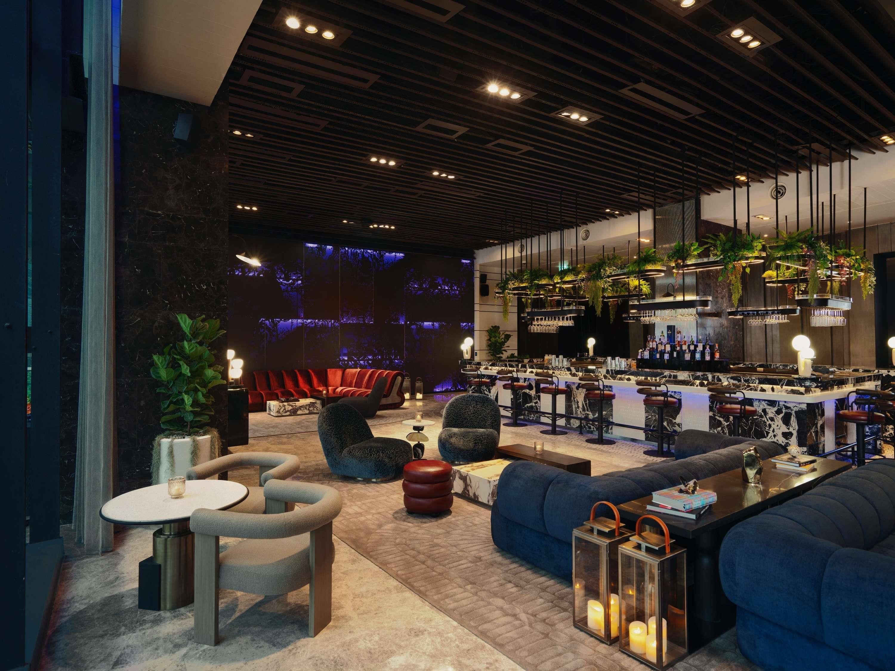 A modern bar area with seating, a bar counter, and ambient lighting.