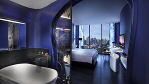Una habitación de hotel moderna con vistas a la ciudad, una bañera grande y un diseño espacioso.