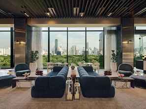 A modern lounge area with a city view, large windows, and contemporary furniture. - SO/ Bangkok (Bangkok)