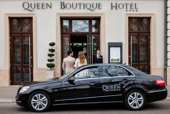 Une voiture noire, sur laquelle on pouvait lire « QUEEN BOUTIQUE HOTEL », était garée devant l’entrée de l’hôtel.