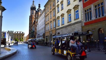 Eine Kopfsteinpflasterstraße mit einem historischen Gebäude und einem Kirchturm im Hintergrund.