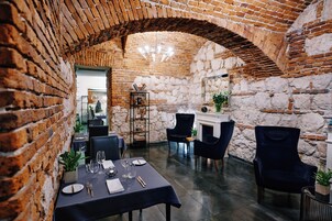 A dining area with brick walls, a stone fireplace, and modern furniture.