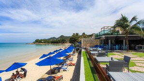 A beachside hotel with sun loungers and umbrellas, a pool area, and a view of the ocean. - Samui Resotel Beach Resort (Koh Samui)