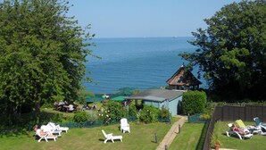A coastal view with a gazebo, lounge chairs, and a small building. - Luccombe Manor Country House Hotel (Shanklin)