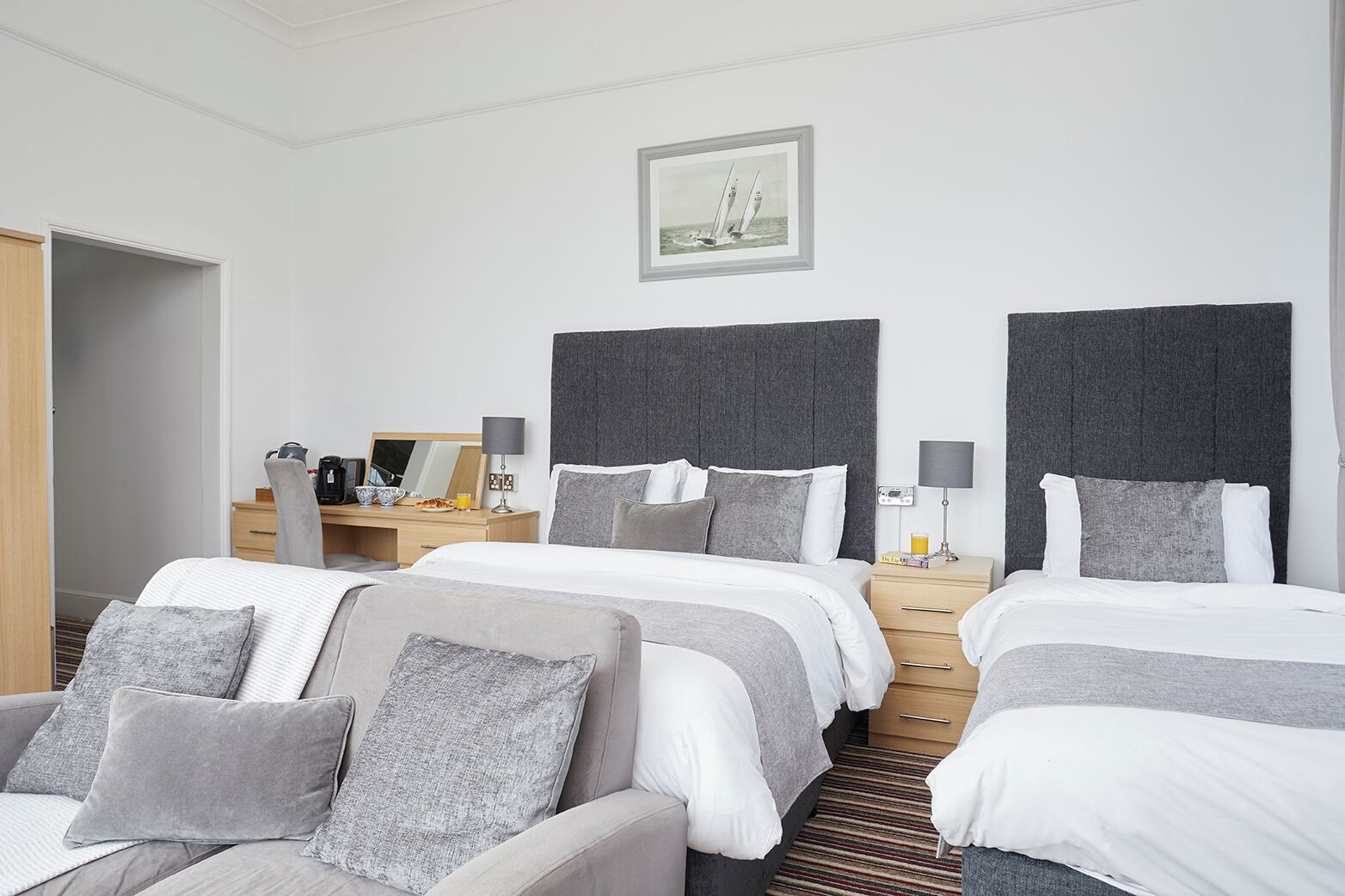 Habitación de hotel con dos camas, un escritorio y una silla.
