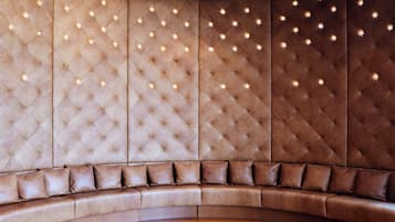 A curved sofa with a tufted backrest and a wooden floor.