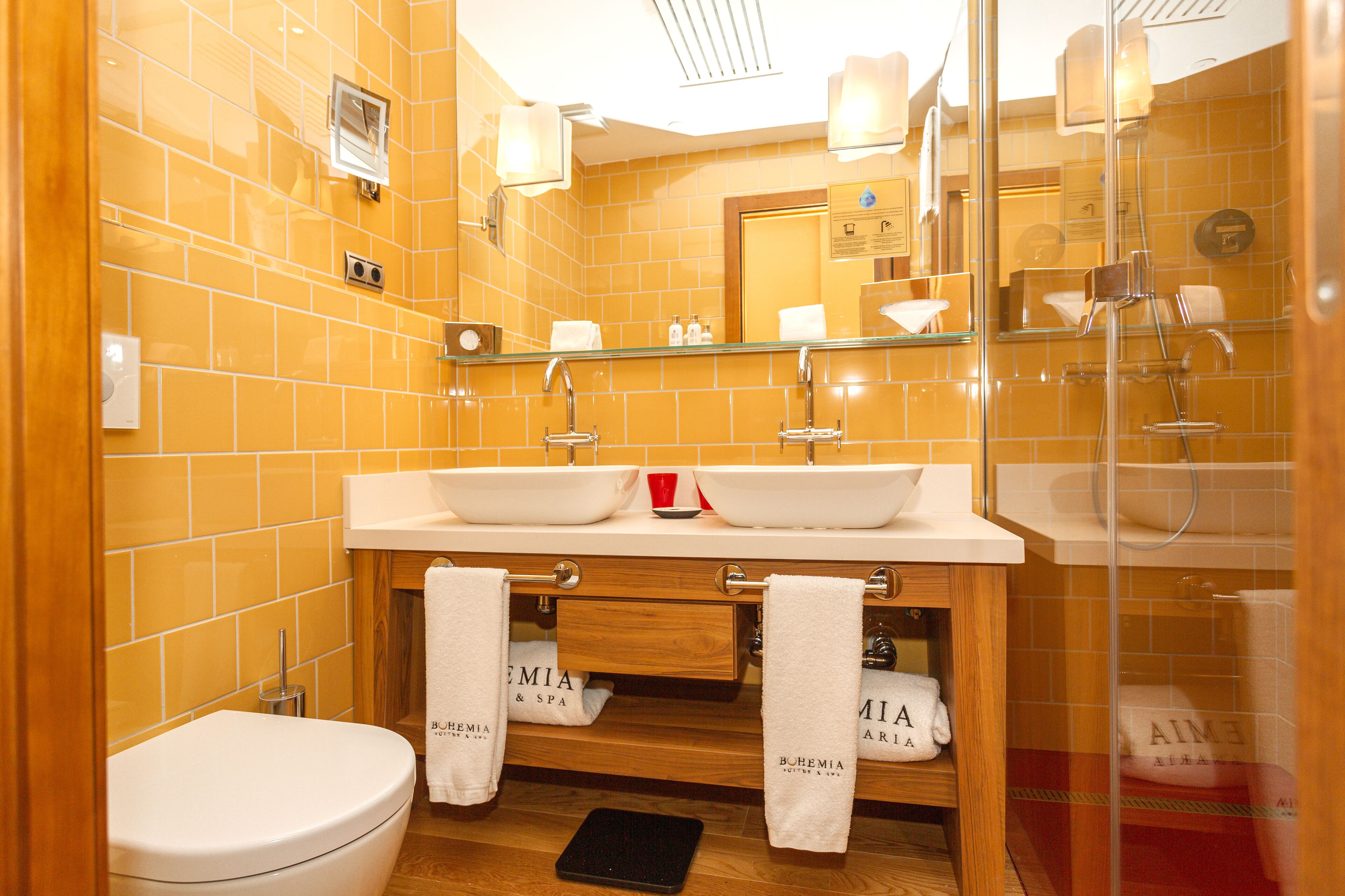 Une salle de bain avec deux lavabos, des toilettes et un espace douche.