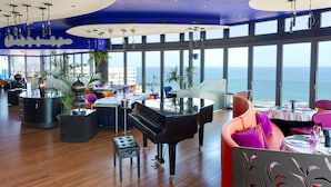 A spacious dining area with a grand piano, large windows offering ocean views, and modern decor. - Bohemia Suites & Spa - Adults only (San Bartolomé de Tirajana)