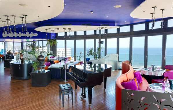 A spacious dining area with a grand piano, large windows offering ocean views, and modern decor. - Bohemia Suites & Spa - Adults only (San Bartolomé de Tirajana)