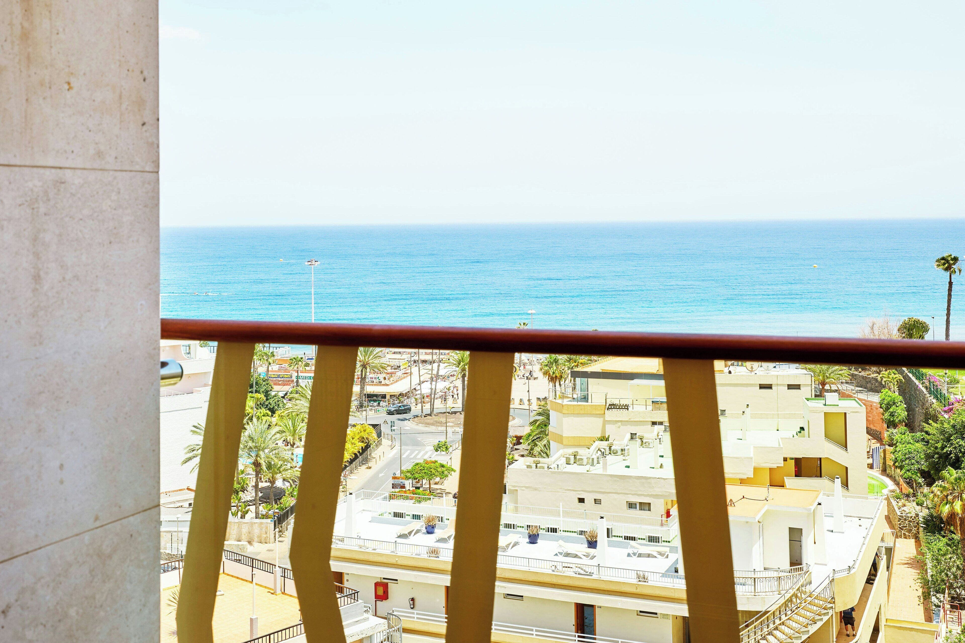 Un balcón con vistas al mar y al paisaje urbano.